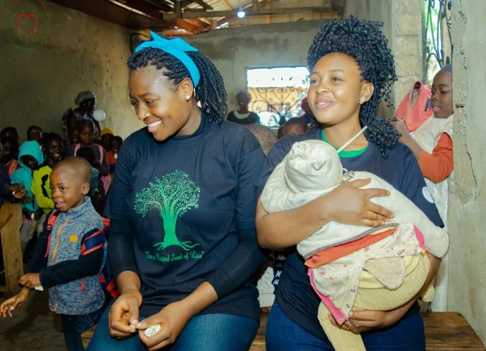 A community member helps children with learning materials.