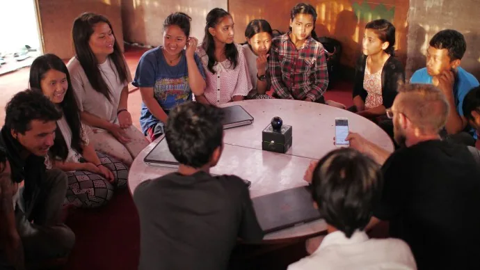 A small group meets around a table for a community discussion.